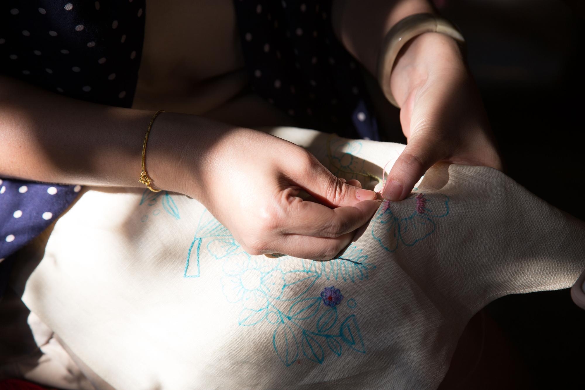 Hands finishing an embroidered patch